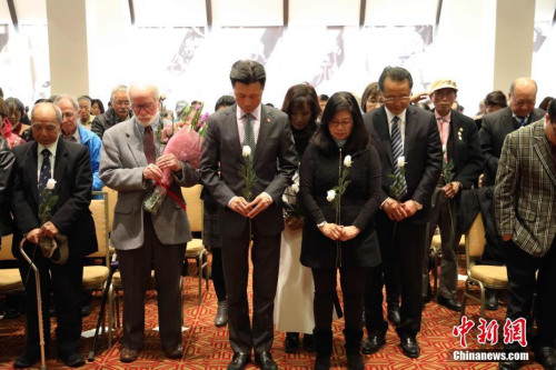 12月10日下午，美國(guó)舊金山中華文化中心，中英文口號(hào)聲不斷響起，由南京大屠殺索賠聯(lián)盟、舊金山灣區(qū)中國(guó)統(tǒng)一促進(jìn)會(huì)、舊金山抗日史實(shí)維護(hù)會(huì)和慰安婦正義聯(lián)盟聯(lián)合主辦的“南京祭”紀(jì)念活動(dòng)進(jìn)入第21年。來(lái)自華裔、韓裔、菲律賓裔、非裔及白人社區(qū)各界人士500余人，向80年前南京大屠殺的死難者默哀，獻(xiàn)上白色玫瑰。<a target='_blank' >中新社</a>記者 劉丹 攝