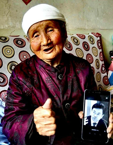 一位受害者舉著童增的照片。