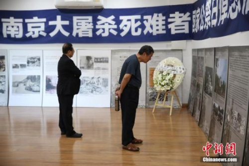 12月13日，悉尼僑界舉行南京大屠殺死難者國家公祭日悼念活動，30多個社團的近百名華僑華人參加。圖為與會者參觀“南京大屠殺”圖片展。 <a target='_blank' >中新社</a>記者 陶社蘭 攝