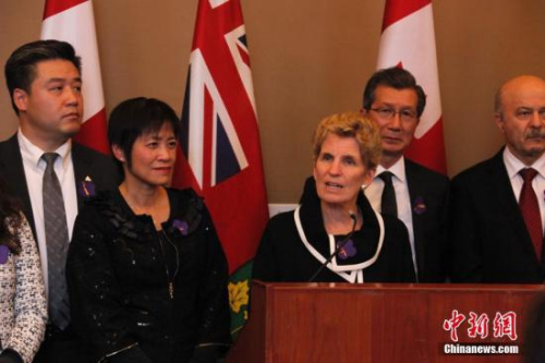 在南京大屠殺80周年之際，當?shù)貢r間12月13日，加拿大安大略省省議會舉行南京大屠殺紀念活動。圖為安省省長韋恩(中)受邀出席在安省議會大樓內舉行的一場紀念會，并表示支持華人社區(qū)開展南京大屠殺紀念活動。<a target='_blank' >中新社</a>記者 余瑞冬 攝