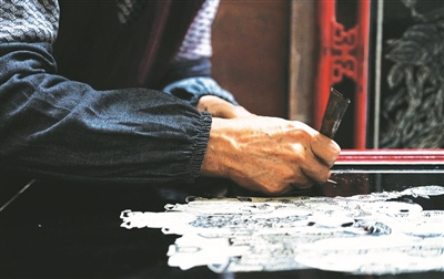 莊順華做推光漆雕畫。