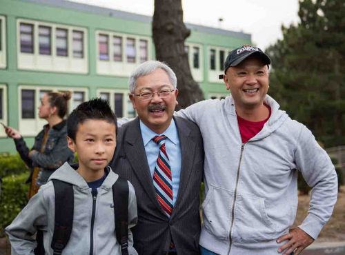 李孟賢(中)視察舊金山學區(qū)訪谷中學時與學生及家長合影。(圖片來源：市長辦公室提供)