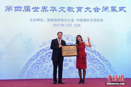 12月20日，第四屆世界華文教育大會在北京閉幕。圖為國務院僑務辦公室黨組書記、副主任許又聲(左)向法國小熊貓學校校長羅堅海外華文教育示范學校授牌。 <a target='_blank' >中新社</a>記者 崔楠 攝