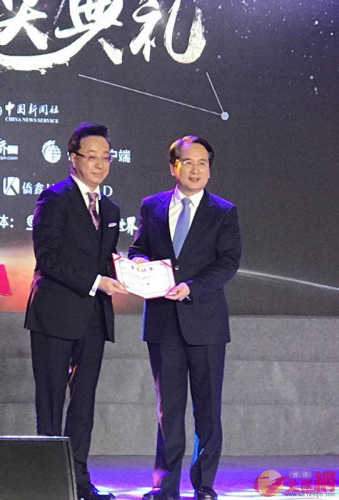 國務(wù)院僑辦副主任譚天星（右）向屠海鳴（左）頒發(fā)獲獎證書。