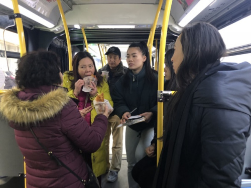 牛毓琳(右)為包厘街85號住戶準(zhǔn)備三明治，其辦公室工作人員幫助租戶登記。 (美國《世界日報》)