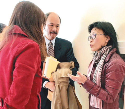 吳女士(右)通過(guò)翻譯員(左)與她的物業(yè)的保險(xiǎn)公司律師(中)在庭外分析法官判決結(jié)果。(美國(guó)《世界日?qǐng)?bào)》/黃少華 攝)。