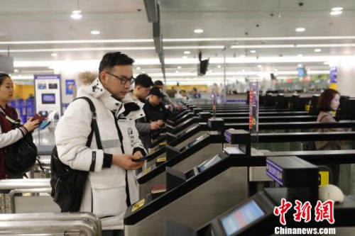 資料圖：旅客在浦東機(jī)場(chǎng)T2航站樓出境大廳內(nèi)掃登機(jī)牌、刷護(hù)照、按指紋拍照片，10多秒就能自助出境通關(guān)。　殷立勤　攝