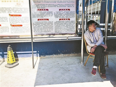 劉斌在派出所的遮陽棚下等待被綁架女友的消息。