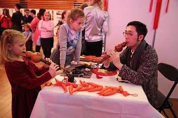 小朋友學(xué)吹葫蘆絲。