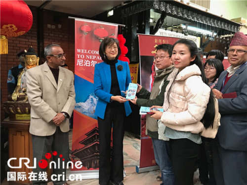 于紅大使為中國游客贈送《來尼泊爾中國公民領(lǐng)事保護與協(xié)助指南》。