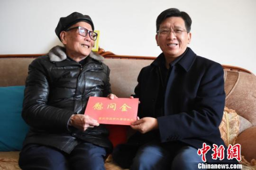 圖為重慶市人民政府外事僑務(wù)辦公室黨組書(shū)記、主任吳康明向南僑機(jī)工蔣印生送上慰問(wèn)金。　周毅 攝