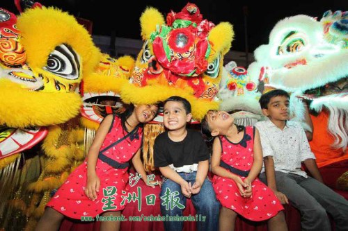 與醒獅近距離接觸，印裔孩童興奮不已。（馬來西亞《星洲日報(bào)》）
