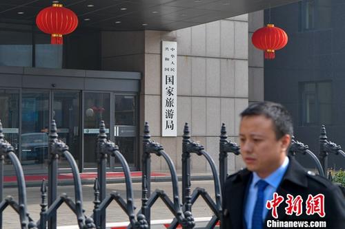 3月13日下午，一名男子從國家旅游局大門前走過。當(dāng)日，《國務(wù)院機(jī)構(gòu)改革方案》提請十三屆全國人大一次會議審議。方案提出，組建文化和旅游部，不再保留文化部、國家旅游局。<a target='_blank' >中新社</a>記者 駱云飛 攝