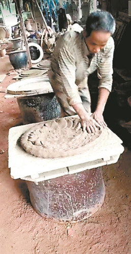 工人們仍然用古老的手工拍打瓦缸的粗胚。