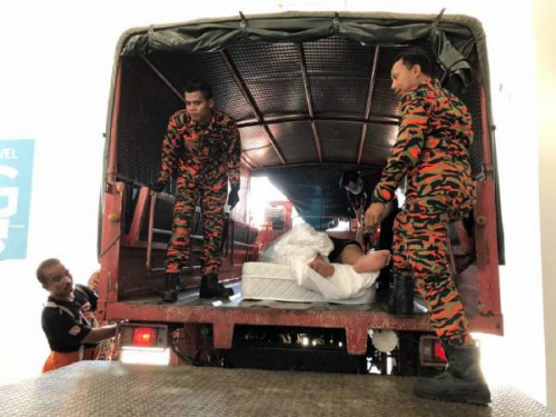 華裔男子被抬上卡車(chē)送往醫(yī)院。（馬來(lái)西亞《中國(guó)報(bào)》）