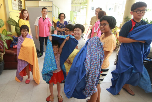 孩子們拿到百家被非常開心。（馬來西亞《星洲日報》圖片）