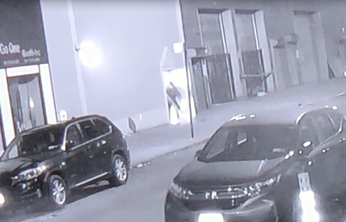 夜店內(nèi)有人出門拖地清理門口。