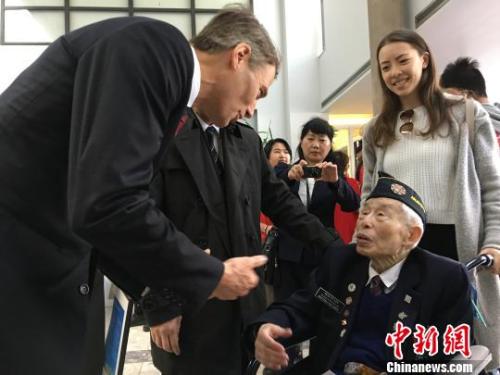 4月22日，溫哥華市長羅品信(Gregor Robertson)在就歧視華人歷史向華人道歉的市議會特別會議結束后，與出席會議的95歲華裔退伍老兵李文英交談。　余瑞冬 攝