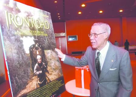 電影《鐵路》2009年在加拿大首映，作為鐵路華工的后裔及曾繳交過人頭稅的加拿大鐵路華工基金會名譽會長盤占元，看著電影海報大有感觸。(加拿大《明報》/容成達攝)