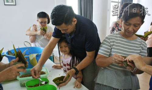 家長帶著小朋友一起包粽子，享受假期的親子樂。（馬來西亞《星洲日報》）