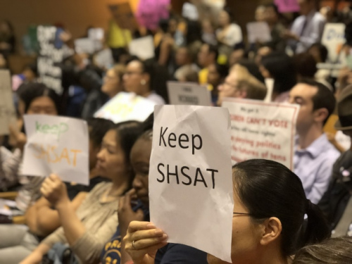 針對特殊高中改革，不少家長帶著抗議牌前往參加會議。(美國《世界日報》/黃伊奕攝)