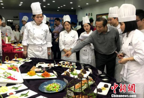  資料圖：老師點評學(xué)生淮揚菜作品?！〈藜衙?攝