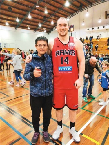 　圖為吳宇森在新西蘭球館觀看籃球賽時和球員合影留念。