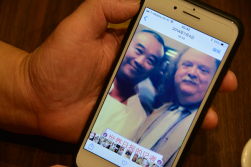 五師傅向記者展示與Jonathan的合照，他將Jonathan稱為知音。(美國《世界日報》／王千惠 攝)