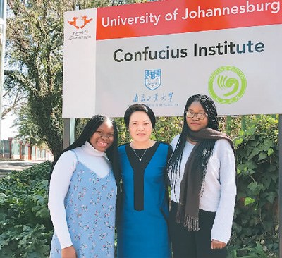 約翰內斯堡大學孔子學院中方院長彭奕(中)與兩名非裔學生合影。