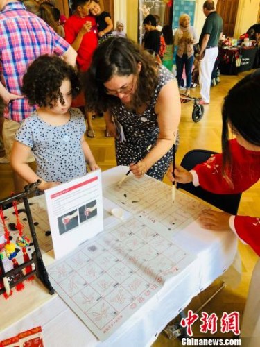 當(dāng)?shù)貢r(shí)間8月4日，美國首都華盛頓的美國革命女兒博物館舉辦“2018世界博覽會(huì)”(World's Fair)。華盛頓亞洲文化中心、華加視頻作為首個(gè)受邀展示中華傳統(tǒng)文化的合作方，為活動(dòng)現(xiàn)場增添了濃郁的東方色彩。圖為美國觀眾認(rèn)真學(xué)習(xí)中國書法技巧?！ochelle Wang　攝