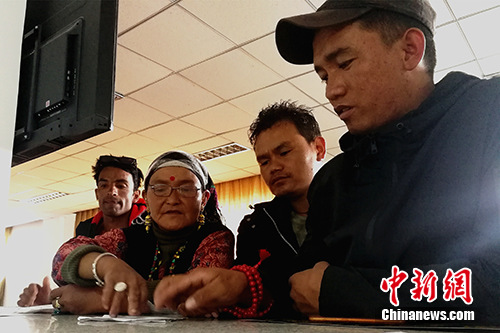 圖為今年57歲的尼泊爾商人贊達熱·瓦迪(左二)在阿里獅泉河海關普蘭工作點的業(yè)務大廳內(nèi)辦理通關手續(xù)。<a target='_blank' >中新社</a>記者 趙延 攝