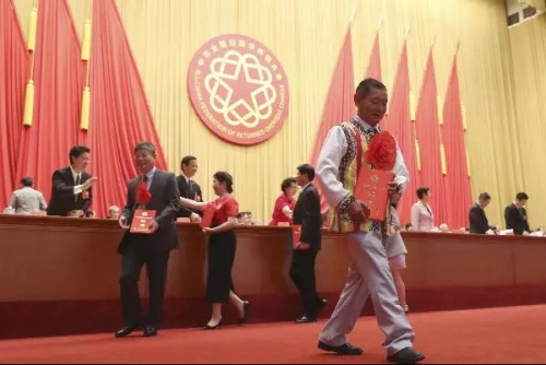 高德榮(前)手捧榮譽(yù)證書。<a target='_blank' >中新社</a>記者 盛佳鵬 攝