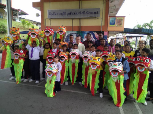 周世揚(yáng)（后排中）贈(zèng)送舞獅予羅白淡小，促進(jìn)文化交融。（馬來(lái)西亞《光華日?qǐng)?bào)》）