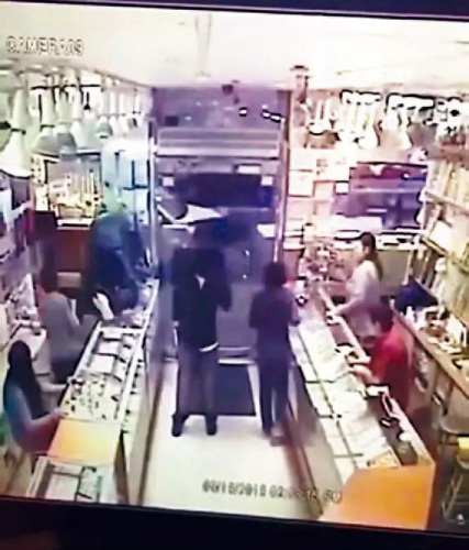 一名嫌犯鳴槍恐嚇，另一人爬進(jìn)柜臺搶走珠寶。視頻截圖