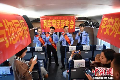 9月19日，乘警們?yōu)槁每退蜕稀栋桨鄷贰稄潖澋脑铝痢返葞资状蠹叶炷茉數(shù)母枨?。?dāng)日，在昆明開往上海的G1376次列車上，昆鐵警方精心組織了一場“中秋列車警民聯(lián)歡會”，為出行的旅客送上中秋節(jié)日祝福。<a target='_blank' >中新社</a>記者 劉冉陽 攝