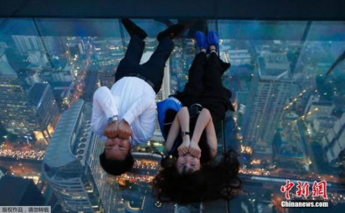 　當?shù)貢r間11月21日，泰國曼谷地標建筑王權云頂大廈(King Power MahaNakhon)的全新空中玻璃步道對外開放，游客在玻璃步道上體驗空中漫步的刺激。