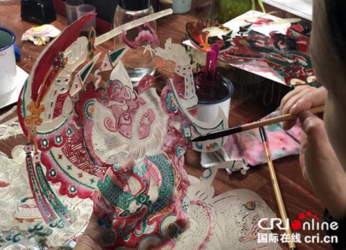 匠人給雕刻完成的皮影上色，手法細致而精準，攝影：張捷