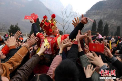 資料圖：“財神”向游客派發(fā)現(xiàn)金紅包。 王中舉 攝