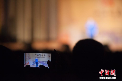 圖為中國男高音歌唱家呂繼宏登臺獻唱時，現場一位觀眾用手機記錄他的表演。<a target='_blank' >中新社</a>記者 馬德林 攝