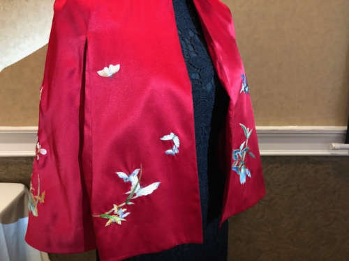 將中國(guó)傳統(tǒng)的蘇繡和西方面料結(jié)合的斗篷。(美國(guó)《世界日?qǐng)?bào)》/張宏 攝)