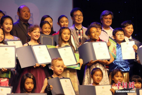 當(dāng)?shù)貢r(shí)間6月9日，在多倫多華文媒體加拿大新動(dòng)力傳媒集團(tuán)主辦的小主持人大賽結(jié)束后，獲獎(jiǎng)小選手們與主辦方代表、評(píng)委等合影。該項(xiàng)賽事最終從40余名參賽小選手中為加拿大首檔中文少兒電視節(jié)目《海貍家族》評(píng)選出首批15名小主持人。<a target='_blank' >中新社</a>記者 余瑞冬 攝