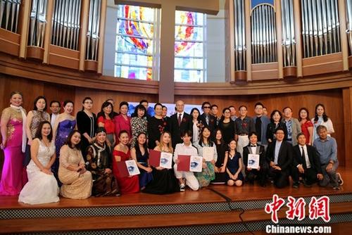 資料圖：當(dāng)?shù)貢r(shí)間6月15日，2019年“文化中國(guó)·水立方杯”海外華人中文歌曲大賽休斯敦賽區(qū)選拔賽在美國(guó)休斯敦舉行。圖為參賽選手、頒獎(jiǎng)嘉賓及志愿者等在賽后合影。<a target='_blank' >中新社</a>記者 曾靜寧 攝