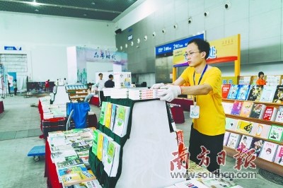 工作人員將書籍整齊地?cái)[在展臺(tái)上