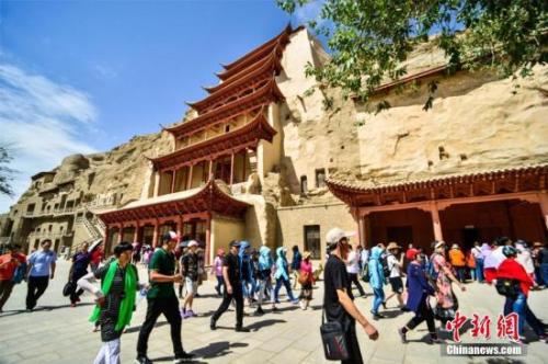 資料圖：莫高窟標(biāo)志性建筑“九層樓”前的游人如織。王斌銀 攝