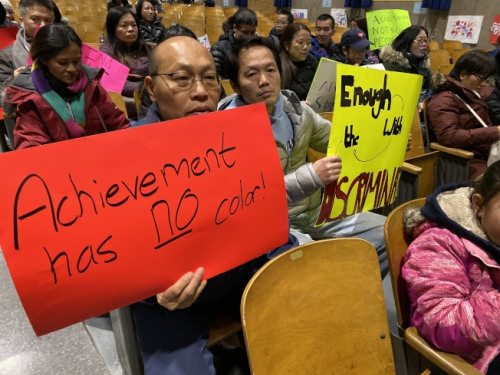 紐約上百名華裔家長手舉抗議牌在會議現(xiàn)場。(美國《世界日報》/黃伊奕 攝)