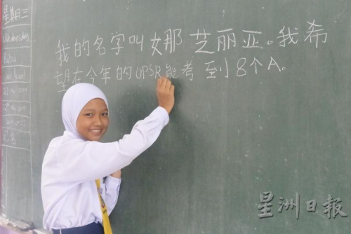娜芝麗亞以工整的中文字體，在黑板上寫下自己的心愿。(來源：星洲日報)