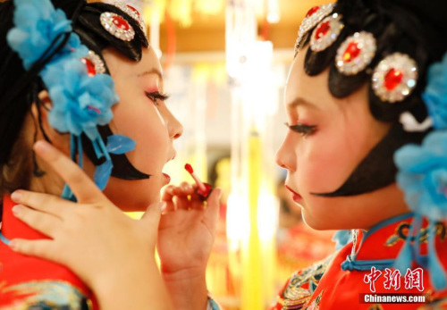 圖為演出前，姐姐幫妹妹化妝。<a target='_blank' >中新社</a>記者 劉關(guān)關(guān) 攝