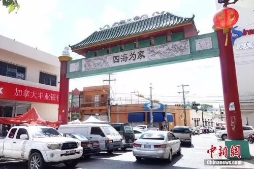 2019年3月24日，在多米尼加首都圣多明各，“唐人街”出口處一座牌坊上刻著“四海為家”四個(gè)大字。這里分布著數(shù)百家華人店鋪、商場(chǎng)和中餐館，是旅居多米尼加華僑華人的主要聚集地。<a target='_blank' >中新社</a>記者莫成雄 攝