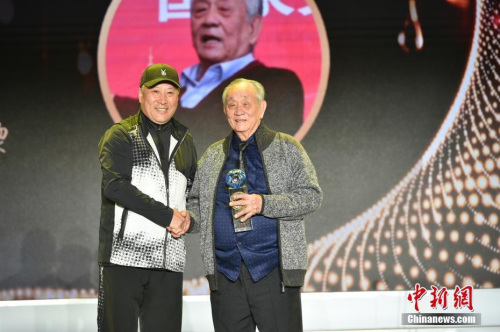 2020年1月8日 “2019全球華僑華人年度評(píng)選頒獎(jiǎng)典禮”舉行，王文教獲評(píng)“年度人物”。圖為中國(guó)羽毛球隊(duì)原總教練、 中國(guó)羽毛球協(xié)會(huì)顧問李永波為王文教（右）獻(xiàn)上獎(jiǎng)杯。<a target='_blank' >中新社</a>記者 翟璐 攝