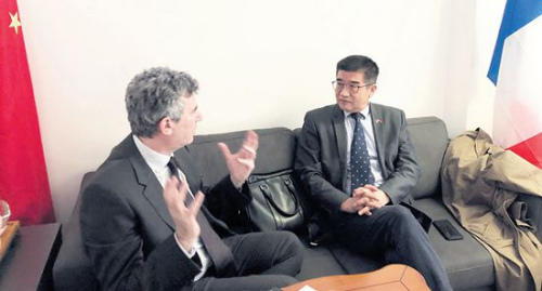 　　正在和客人商討前往中國計(jì)劃的周建防(右)。(《歐洲時(shí)報(bào)》/黃冠杰 攝)